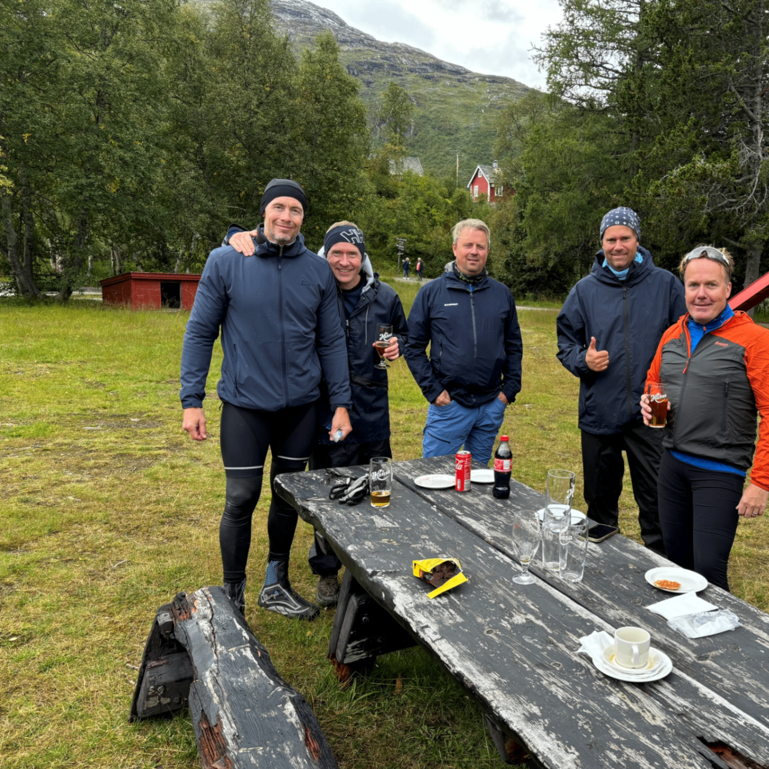 Vennelaget samlet rundt et bord i fjellet med Hansa-pils